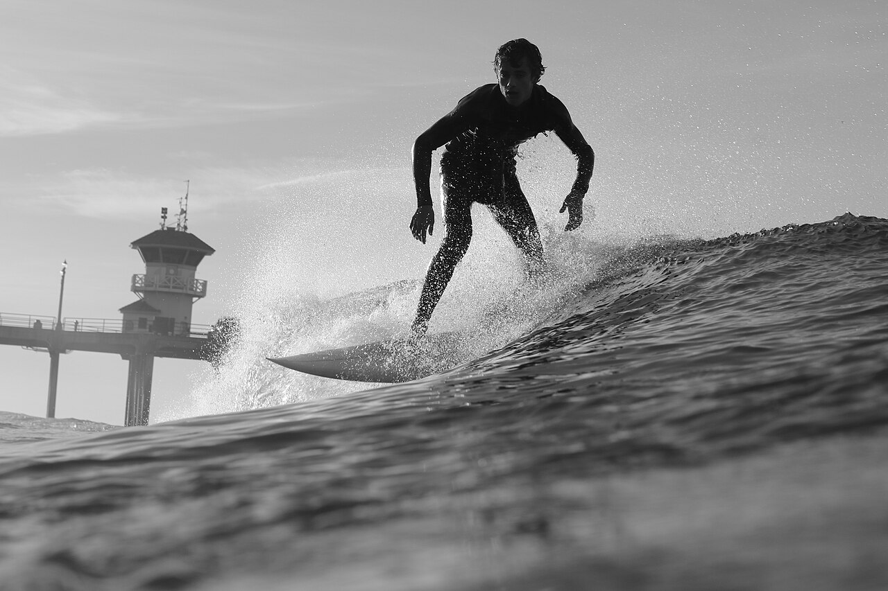 A surfer walking out of the water at Huntington Beach